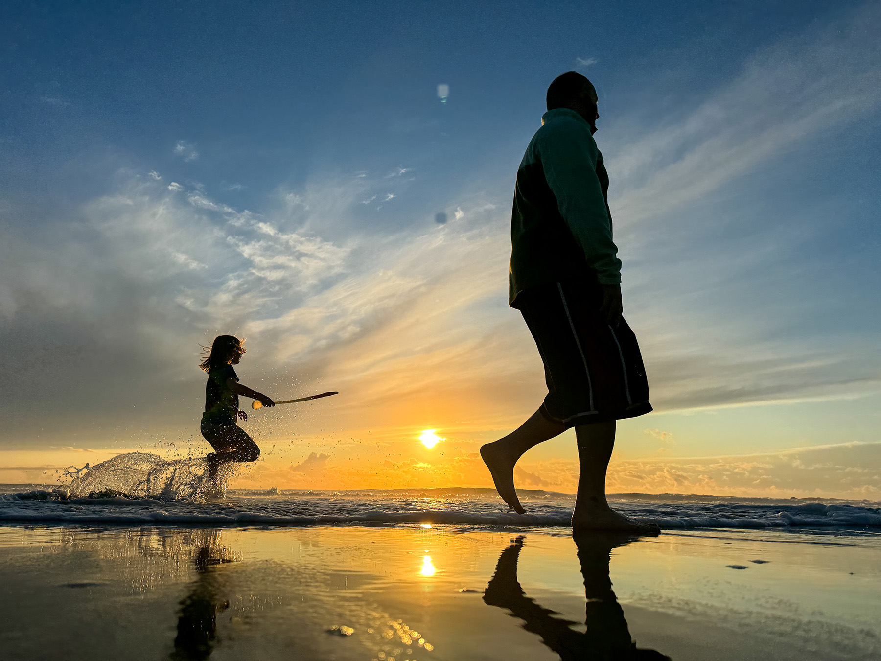 A father and child on an Oregon beach at sunset